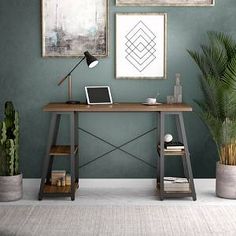 a desk with a laptop on it next to two potted plants