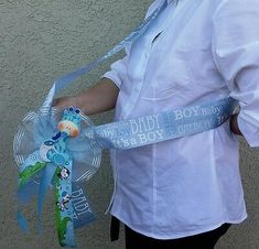 a person wearing a white shirt and holding a blue ribbon