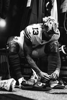 a football player tying his shoes on the ground