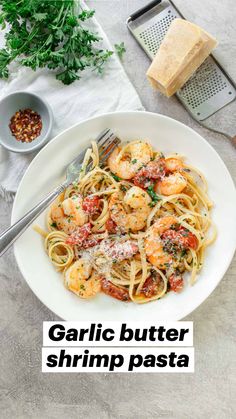 garlic butter shrimp pasta in a white bowl with parmesan bread on the side