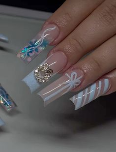 a woman's hand with some white and blue nail polishes on her nails