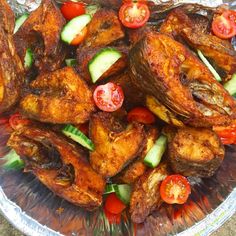 chicken wings with tomatoes, cucumbers and zucchini slices on a platter