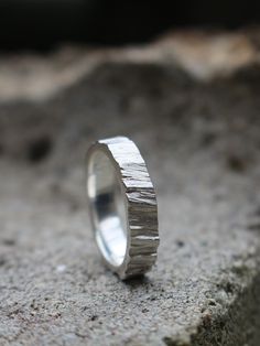 a silver ring sitting on top of a rock