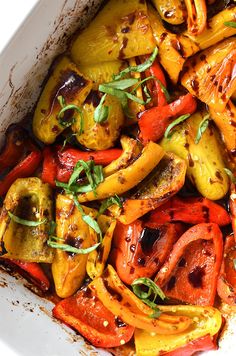 a white bowl filled with lots of different colored peppers