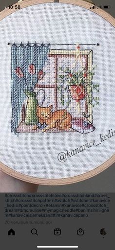 someone is holding up a cross - stitched picture with a cat and dog on it