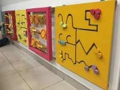 three colorful bulletin boards are on the wall next to each other in a room with tile flooring