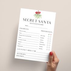 a person holding up a card with the words secret santa written in red on it