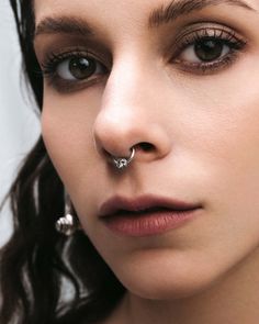 a woman with piercings on her nose looking at the camera