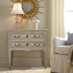 a white dresser sitting next to a window with a clock on it's side