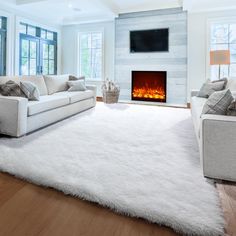 a living room with white furniture and a fireplace