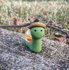 a small toy snail sitting on top of a rock