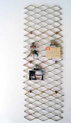 there is a metal wall hanging with pictures and magnets attached to the side of it