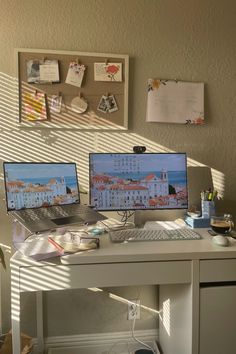 two computer monitors sitting on top of a desk