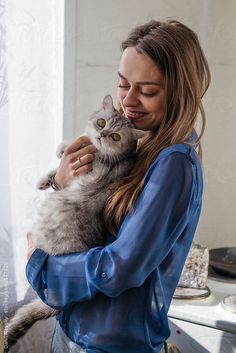 a woman holding a cat in her arms