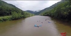 there are many small boats in the water and people on canoes floating down the river