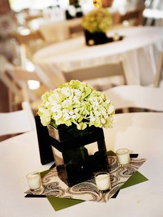 there is a vase with some flowers on it and candles in front of the table