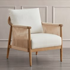 a wooden chair with white cushions on top of a hard wood flooring area next to a wall