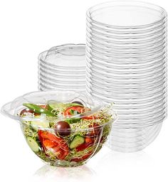 a stack of clear plastic plates with salad in the middle and one bowl on the side