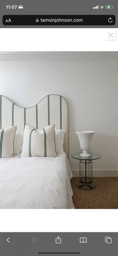 a white bed sitting next to a window in a bedroom