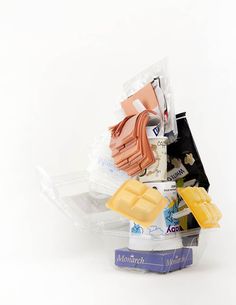 a plastic container filled with assorted items on top of a white table next to a blue box