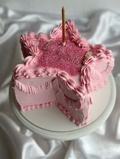 a birthday cake with pink frosting and sprinkles is on a white plate