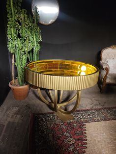 a table with a plant on top and a chair in the corner next to it