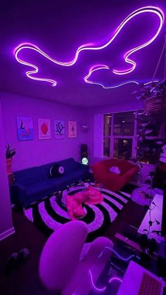 a living room filled with furniture and purple lighting on the ceiling above it is a couch