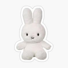 a white stuffed rabbit sitting on top of a table