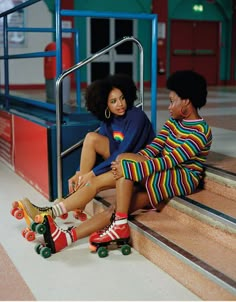 two people sitting on steps with skateboards in front of them and one person wearing colorful clothing