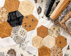 a table topped with lots of different types of quilts and papers on top of each other