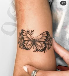 a woman's arm with a butterfly tattoo on it