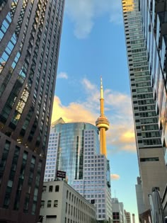 tall buildings in the city with a sky scraper on one side and a yellow spire on the other