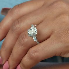 a close up of a person's hand holding an engagement ring