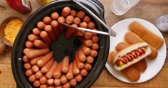 hot dogs and buns in a pan on a table