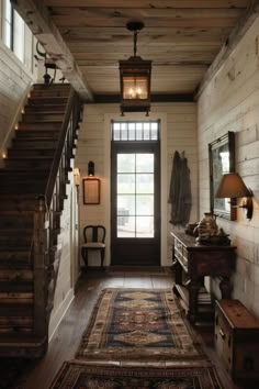 an entry way with stairs and rugs on the floor