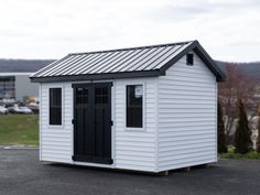 a small white shed sitting on top of a parking lot