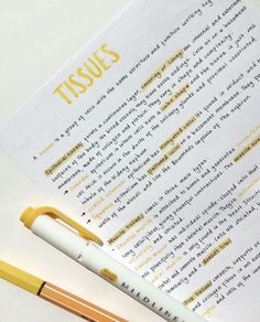 a pen sitting on top of a piece of paper next to a yellow and white marker