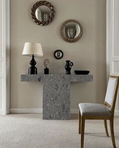 a table with two lamps and mirrors on the wall