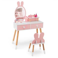 a pink and white desk with a mirror, chair and stuffed animal on the table