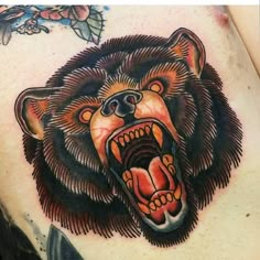 a close up of a bear tattoo on the side of a woman's stomach