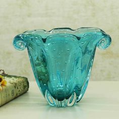 a blue glass vase sitting on top of a table