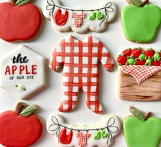 decorated cookies are arranged in the shape of an apple and a man with a basket of apples