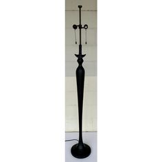 a black floor lamp with two candles on it