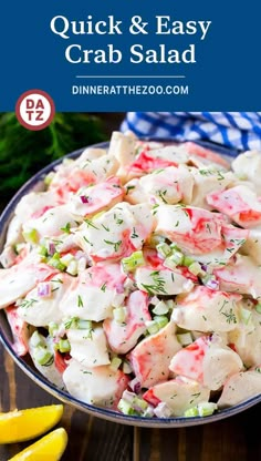 a bowl filled with crab salad next to lemons and parsley on the side