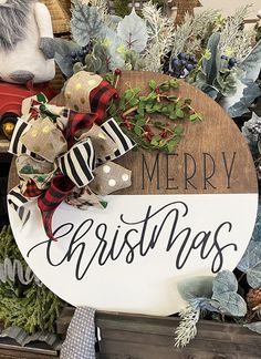 a merry christmas sign is displayed in front of some wreaths and other holiday decorations