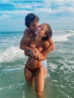 two women in the ocean hugging each other