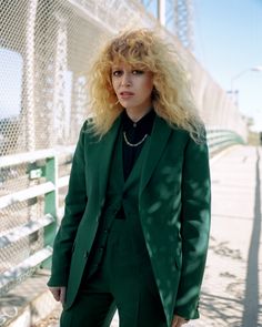 a woman with blonde hair wearing a green suit