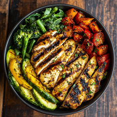 a bowl filled with grilled chicken, vegetables and broccoli