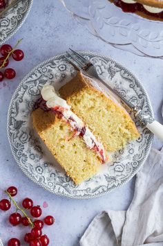 a slice of cake on a plate with cherries and a fork next to it