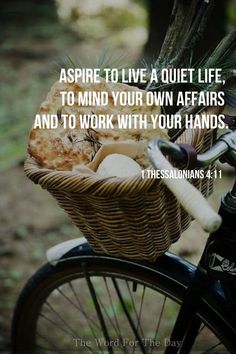 a bicycle with a basket full of bread on the front and side, saying aspire to live a quiet life, to mind your own affairs and to work with your hands